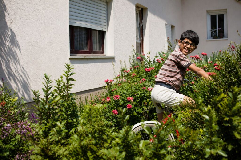 Menino de bicicleta entre flores