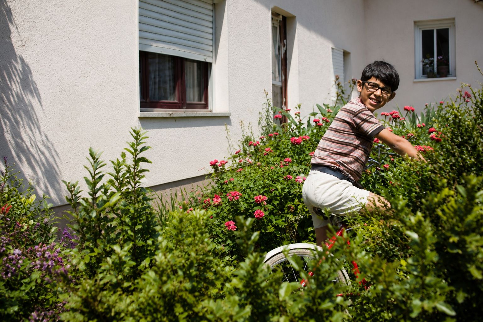 Menino de bicicleta entre flores