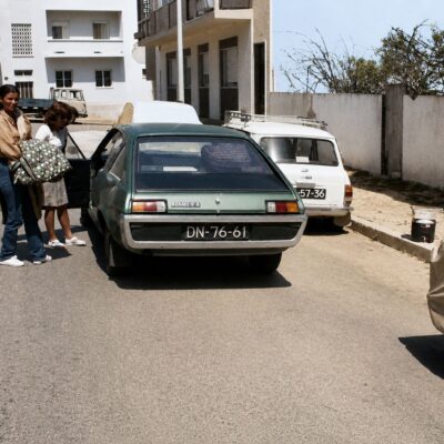 Carros clássicos e malas na rua ensolarada