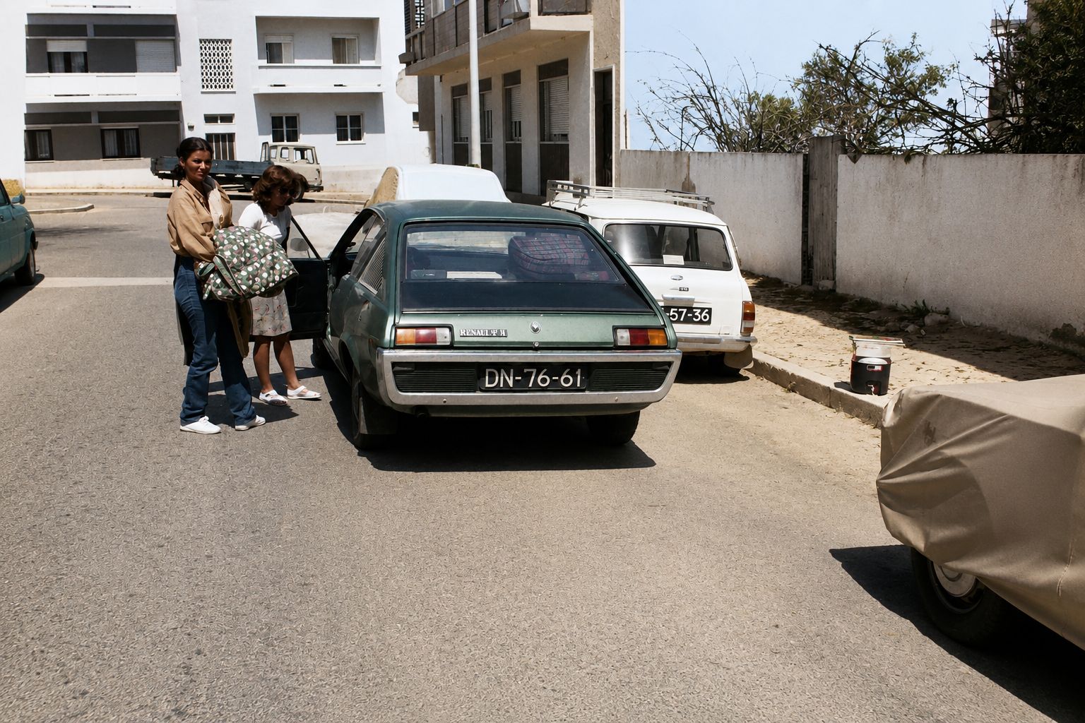 Carros clássicos e malas na rua ensolarada