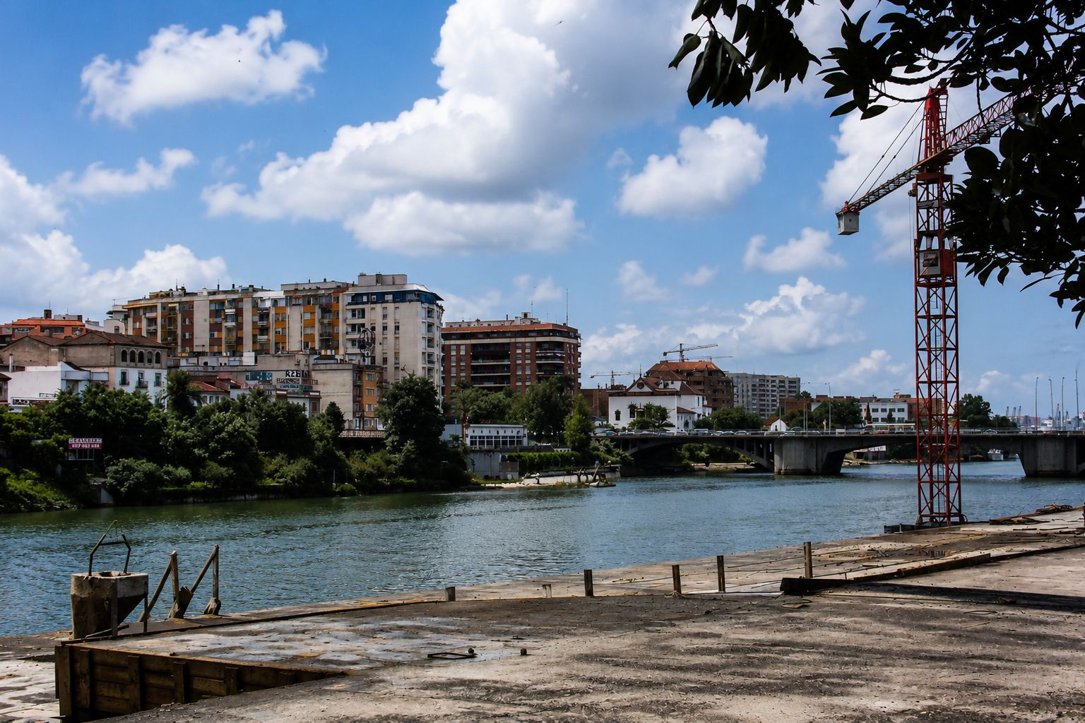 Cais urbano com gruas e rio